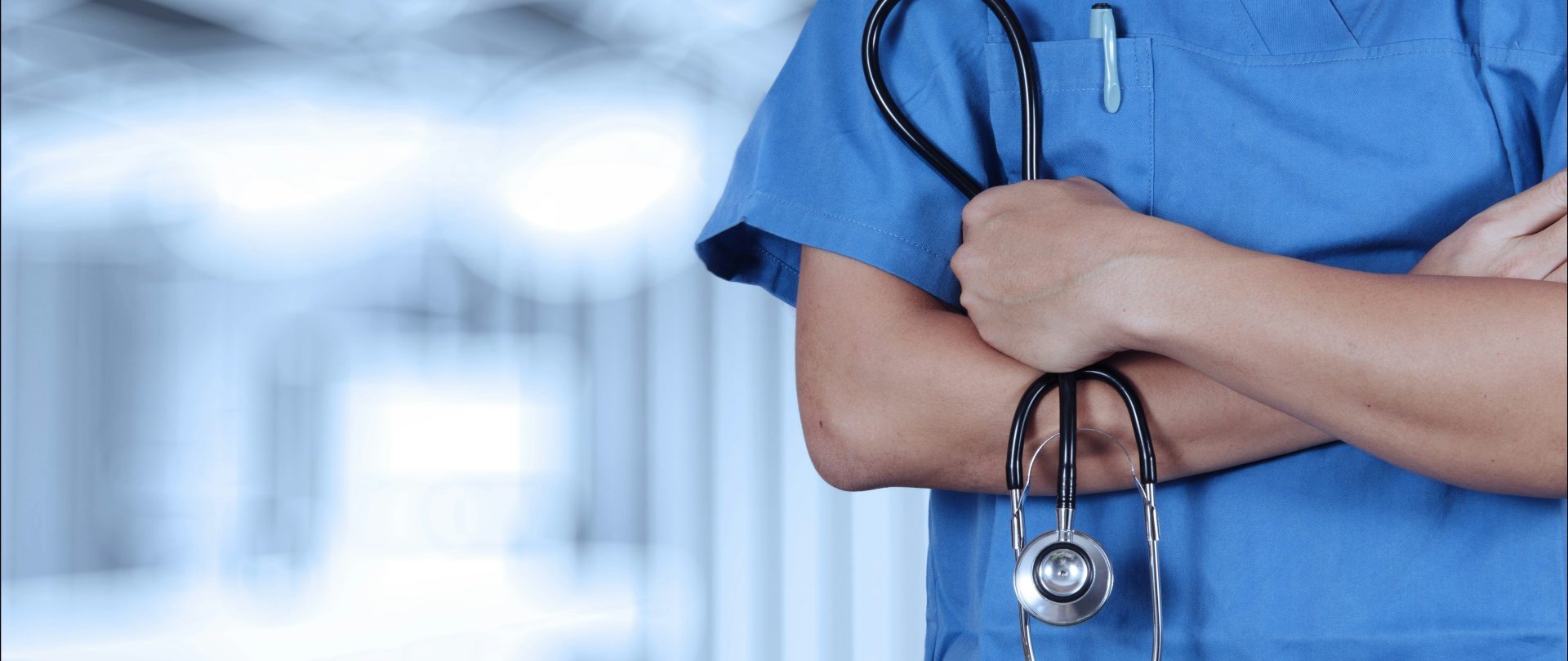 a person in scrubs with a stethoscope on their arm